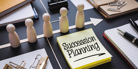 Wooden figures on arrows, near sticky note with "Succession Planning" text, symbolizes business continuity and transition plan