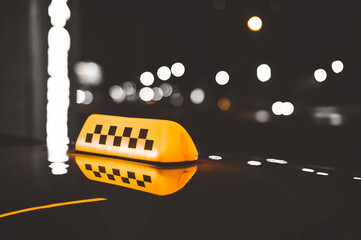 Close-up of taxi sign checker lights. The background of the city night street.
