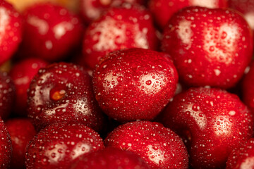 delicious ripe red cherry berries in drops of water, wet red cherry fruits on the kitchen table