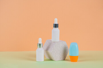 Cosmetic product in tube, bottle, lotion or serum with stylish props on cream background. 