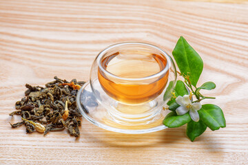 Jasmine green tea in clear cup on wooden table