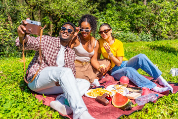 Friends taking selfie with vintage camera at picnic
