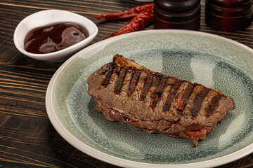 Grilled beef striploin steak with sauce