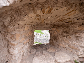 Stone shooting hole in the castle wall with a view of the outer wall of Spiš Castle, an example of...