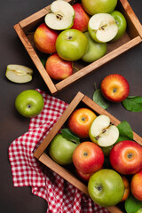 Ripe red and green apples in wooden box on a rusty background