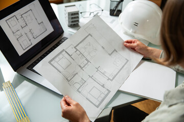 Architect holding and  working on a technichal blueprint project of new apartments in a...