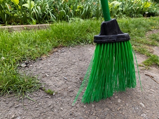 A green broom sitting on the ground in a garden