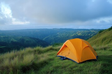An orange tent set against a lush green hillside landscape during a bright day