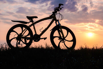 Fototapeta premium Silhouette of a bicycle or bike standing at sunset. no people.