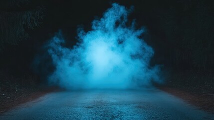 A dark road is dramatically illuminated by a vibrant, glowing blue mist or smoke rising from the asphalt. Eerie and atmospheric