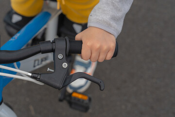 Child Learning to Ride a Bicycle with Hand on Handlebar