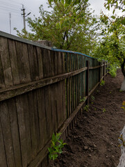 A wooden fence in the middle of a dirt field