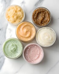 Overhead View of Six Jars of Colorful Textured Body Scrubs on Marble Surface