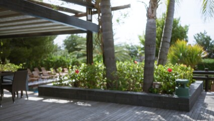 Blurred view of a luxury tropical resort showcasing defocused palm trees and colorful plants in an inviting outdoor setting.