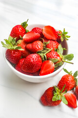 a bowl of strawberries on a ceramic floor as a background