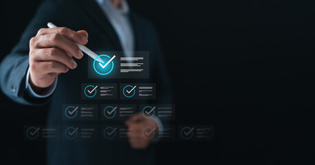 Businessman using digital checklist interface with pen, symbolizing task management, project...