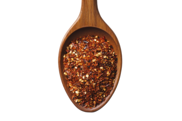 Fiery flakes A wooden spoon cradles a vibrant pile of crushed red pepper a spicy delight against a stark backdrop