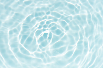 Blue water with ripples on the surface. Defocus blurred transparent blue colored clear calm water surface texture with splashes and bubbles. Water waves with shining pattern texture background.