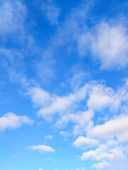 Bright blue sky filled with scattered white clouds creating a serene and airy natural background. Perfect for copy space or environmental themes.