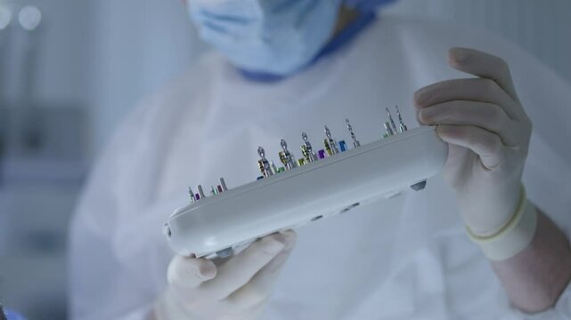  Dentist preparing a dental kit for surgery