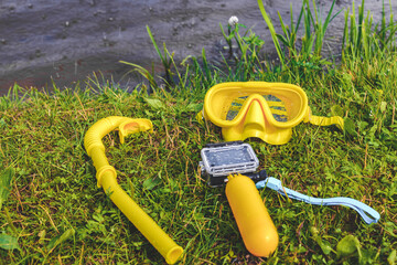 Close-up action camera with waterproof body and yellow float with scuba mask and snorkel.