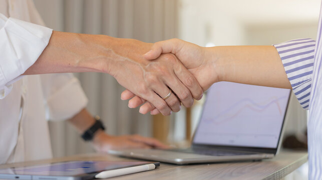 close up ceo team of  businessman handshake with investor while meeting in office room for agreement or deal financial cooperative concept