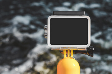 Action camera mockup close-up on the background of water with waves.
