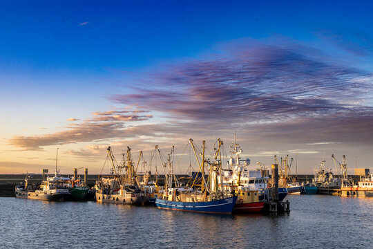 Sunset landscape of Dutch harbor Lauwersoog with fishing ships long the Waddensea in Groningen the Netherlands