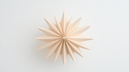 A light beige paper star-shaped decoration hangs from a string against a white background.