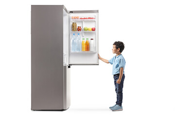 Full length profile shot of a kid opening a fridge
