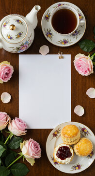 Elegant tea setup with roses and pastries on a wooden table  