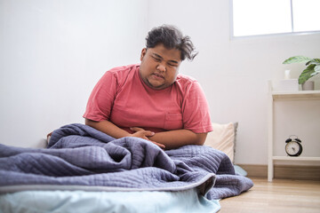 Overweight Male Gripping Belly, Suffering From Stomachache in Bedroom