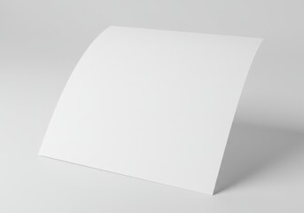 Blank white sheet of paper with a slight curl on a white surface ready for text or design