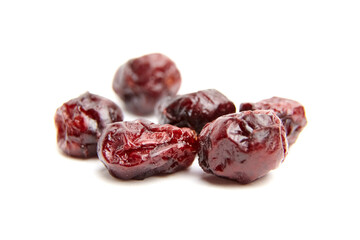 Group of dried cranberries with glossy, wrinkled skin and rich red tones displayed against a clean white backdrop, highlighting texture and natural color