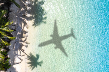 Aerial view of shadow passenger plane silhouette and sandy beach blue sea with waves at sea beach summer vacation sea travel concept