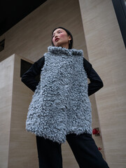 Street style fashion, Asian model in faux fur clothes on a city street.