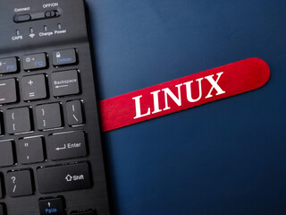 Black keyboard and ice cream stick with the word LINUX on a blue background