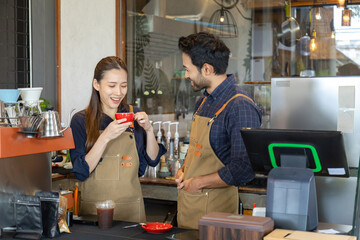 Multicultural couple startup small business bakery cafe restaurant coffee shop wearing apron uniform together partnership, Indian male Asian female barista happy working opening food store teamwork