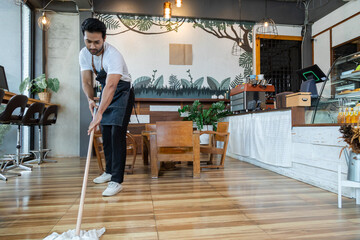 Indian male employee sit and resting after a long day at work. Small business owner coffee shop tired after mopping the floor, waitres secretly fell asleep after working hard. Restaurant owner concept
