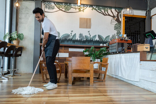 Indian male employee sit and resting after a long day at work. Small business owner coffee shop tired after mopping the floor, waitres secretly fell asleep after working hard. Restaurant owner concept