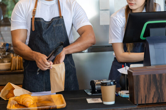 Multicultural couple startup small business bakery cafe restaurant coffee shop wearing apron uniform together partnership, Indian male Asian female barista happy working opening food store teamwork