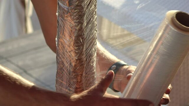 Plastic Wrap, Food, Packaging - Person wrapping food in plastic wrap for protection and preservation.
