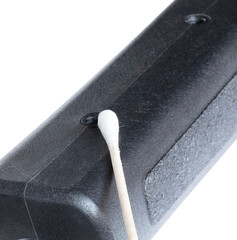Sling stud holes being cleaned on a rifle with a black stock