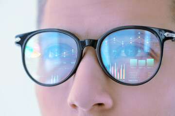 Stock exchange. Trader analyzing data, closeup. Graphs and information reflecting in his eyeglasses