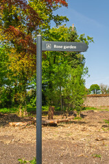 Wooden sign pointing visitors to the rose garden