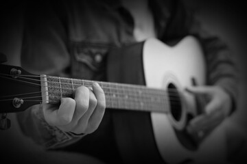 Man playing guitar, closeup. Black and white effect