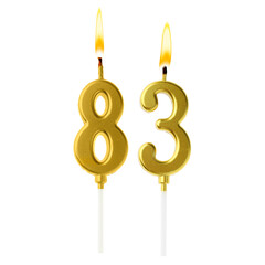 Burning golden cake candles composing number 83 on white background. Festive decoration for...