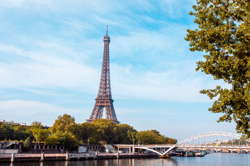 View of the Eiffel Tower in summer with a bright blue sky and the Passerelle Debilly bridge in the frame. Famous for its locks. © BrookelynnBliss