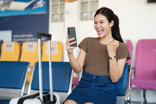 Travel delight: young woman celebrating good news at airport
