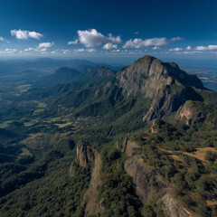 Fototapeta premium Majestic mountain range aerial view lush green forests vibrant blue sky dramatic rock formations